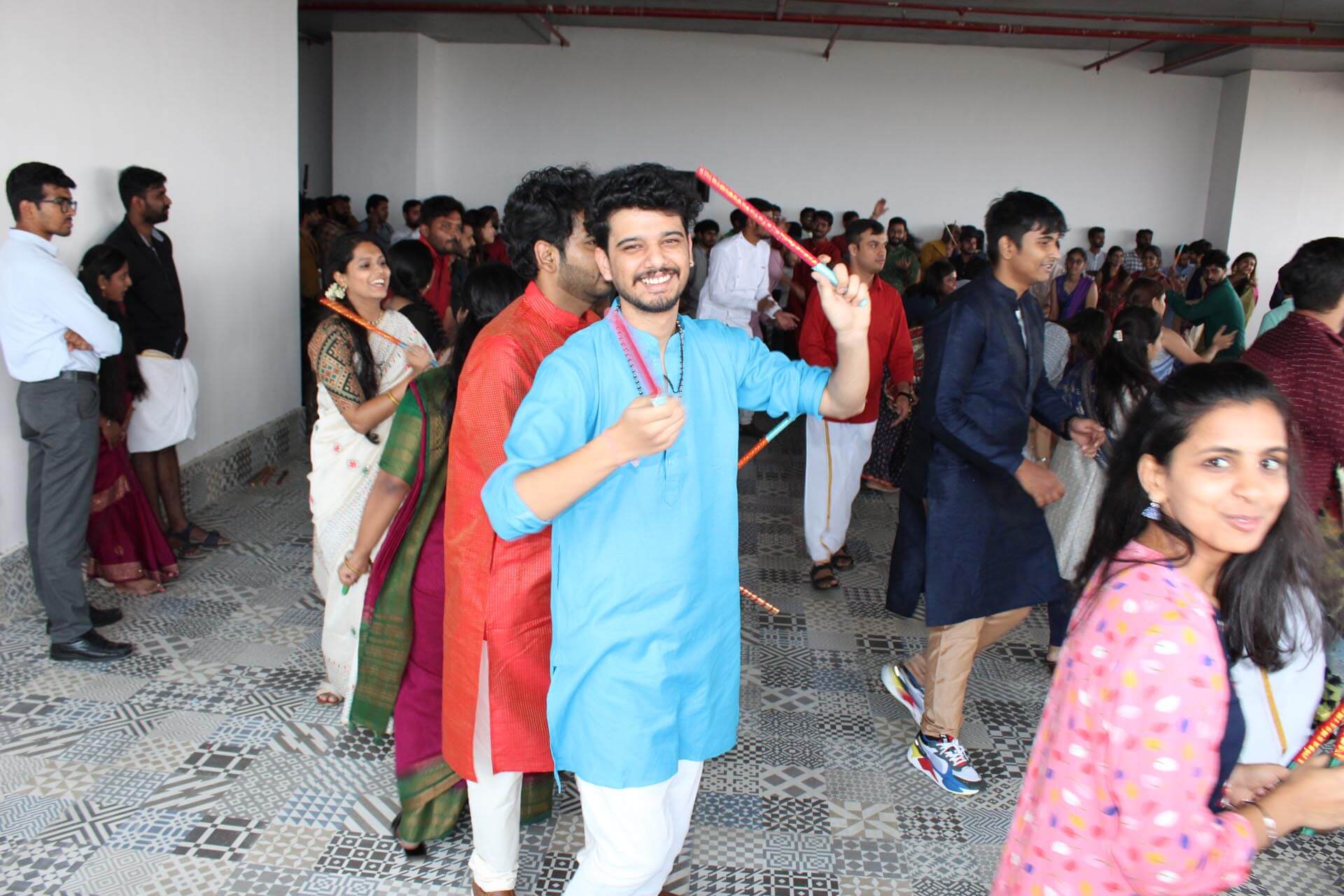 a person holding a stick in a room with people in the background