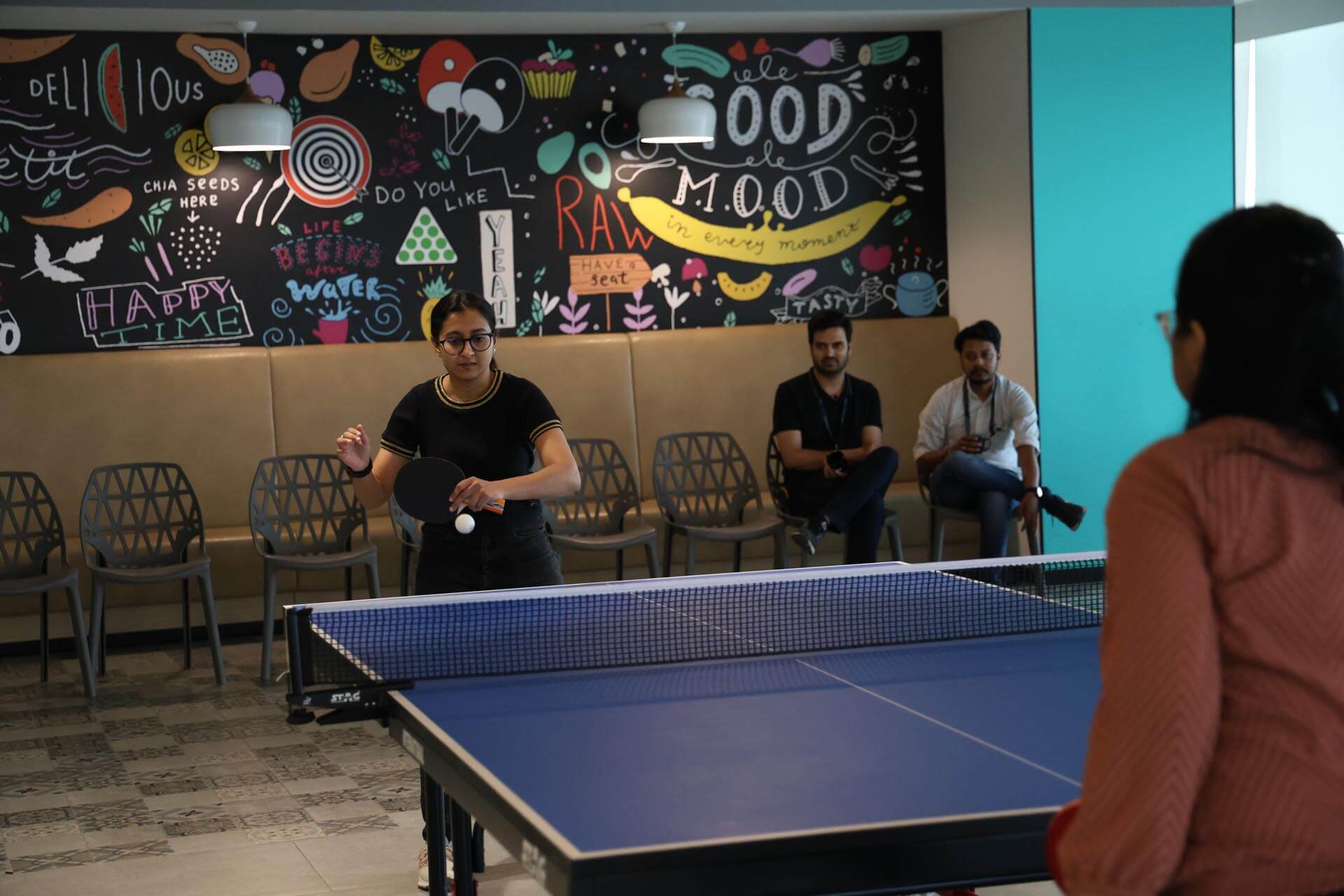 a group of people playing ping pong