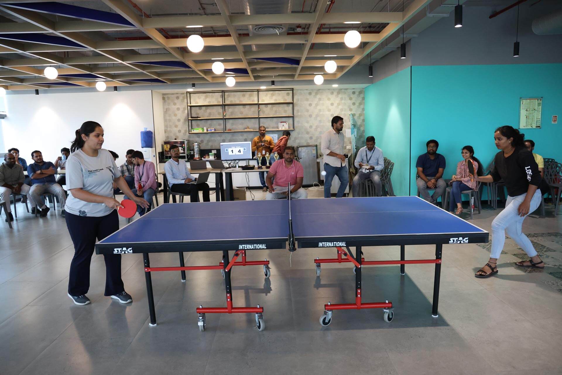 people playing ping pong in a room