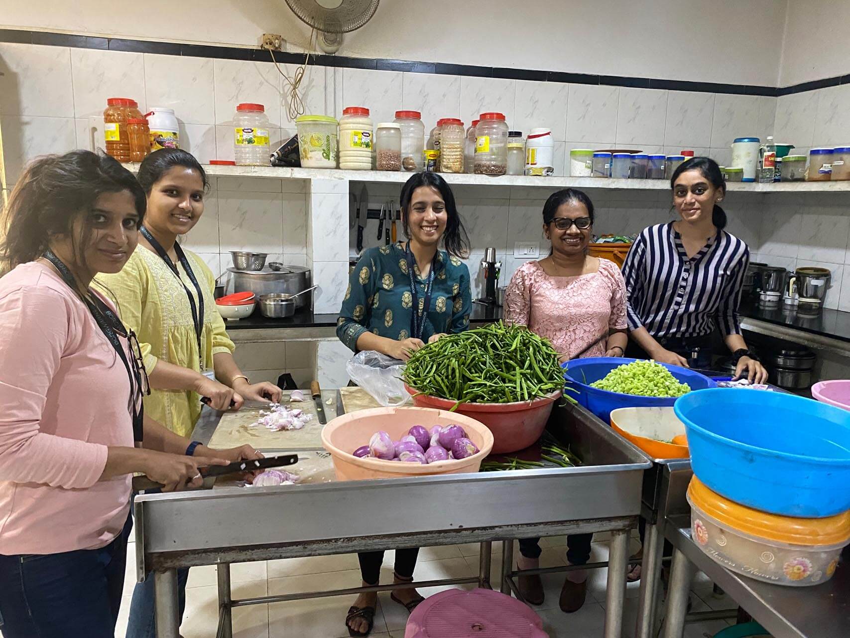 a group of women standing in a kitchen