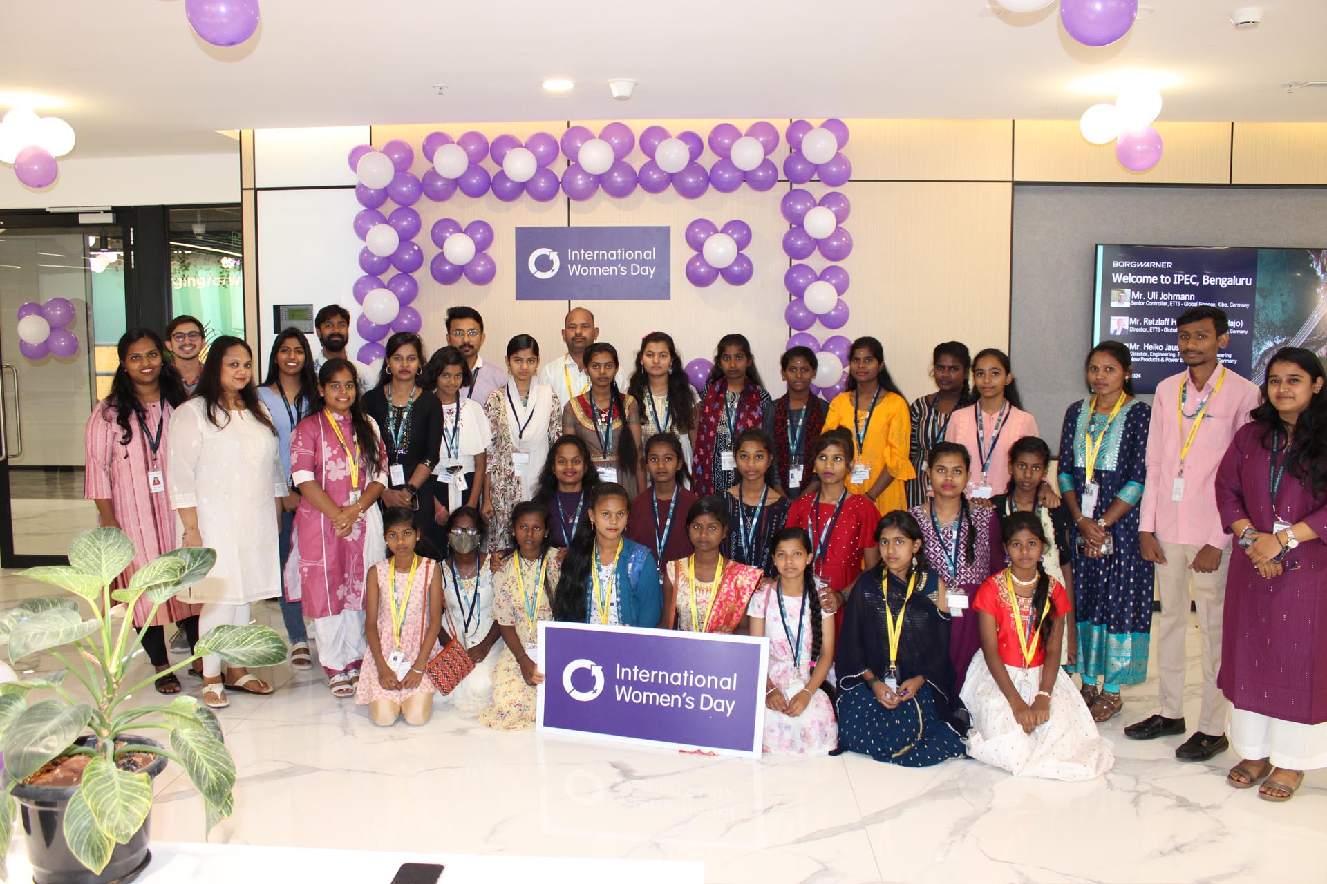 A group of smiling people standing together, posing for a cheerful photo.