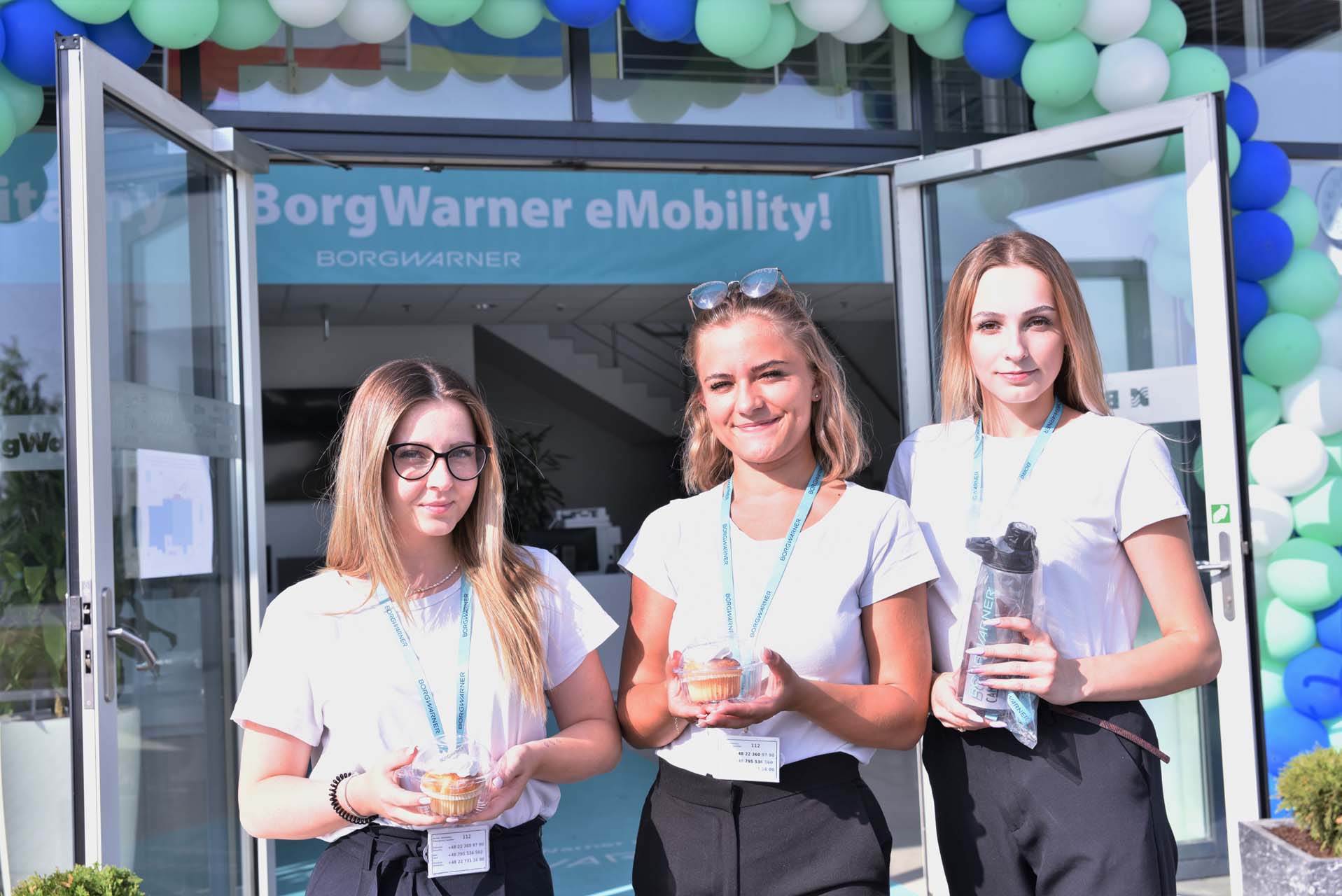 Three women in front of BorgWarner building