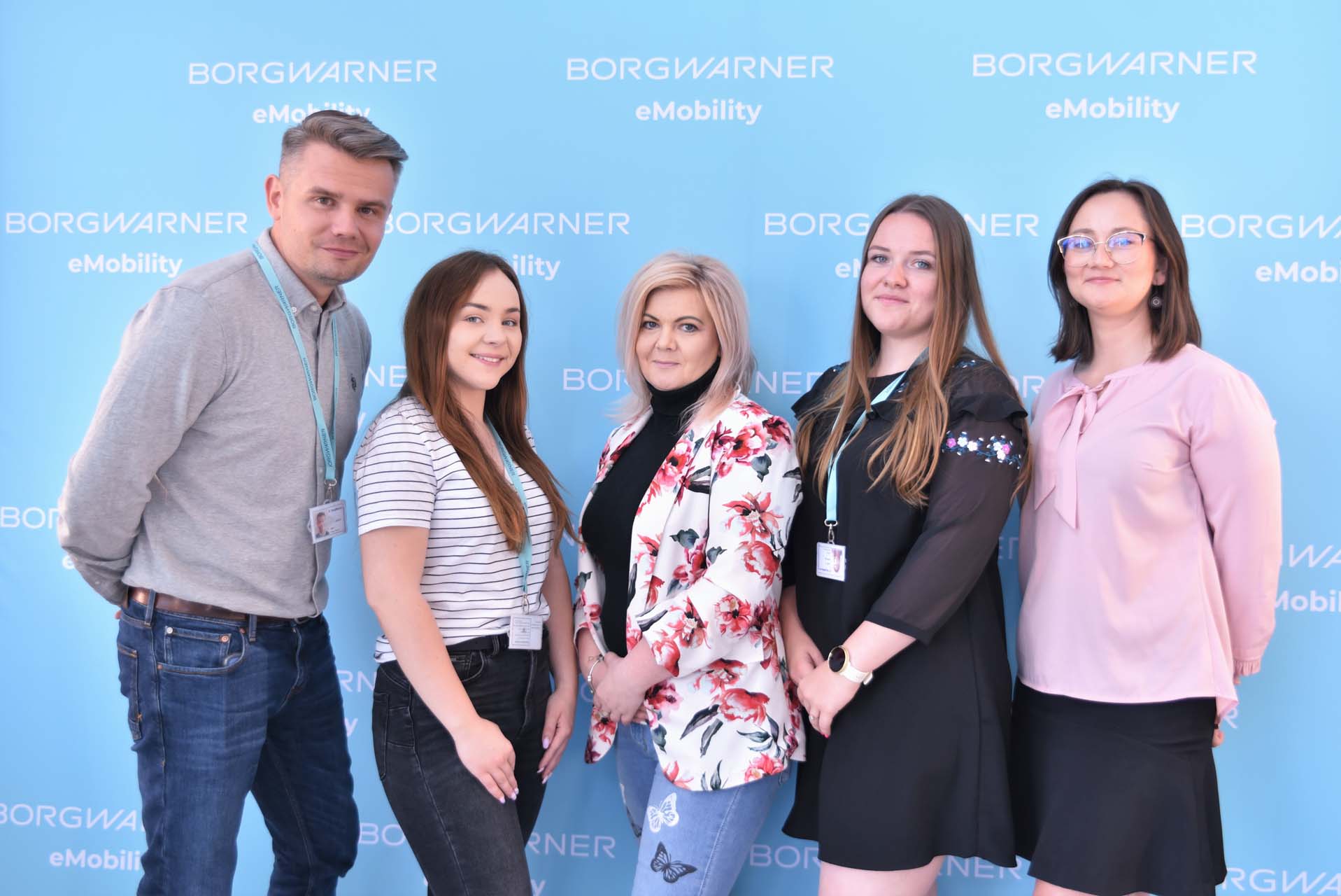 5 people in front of BorgWarner wall