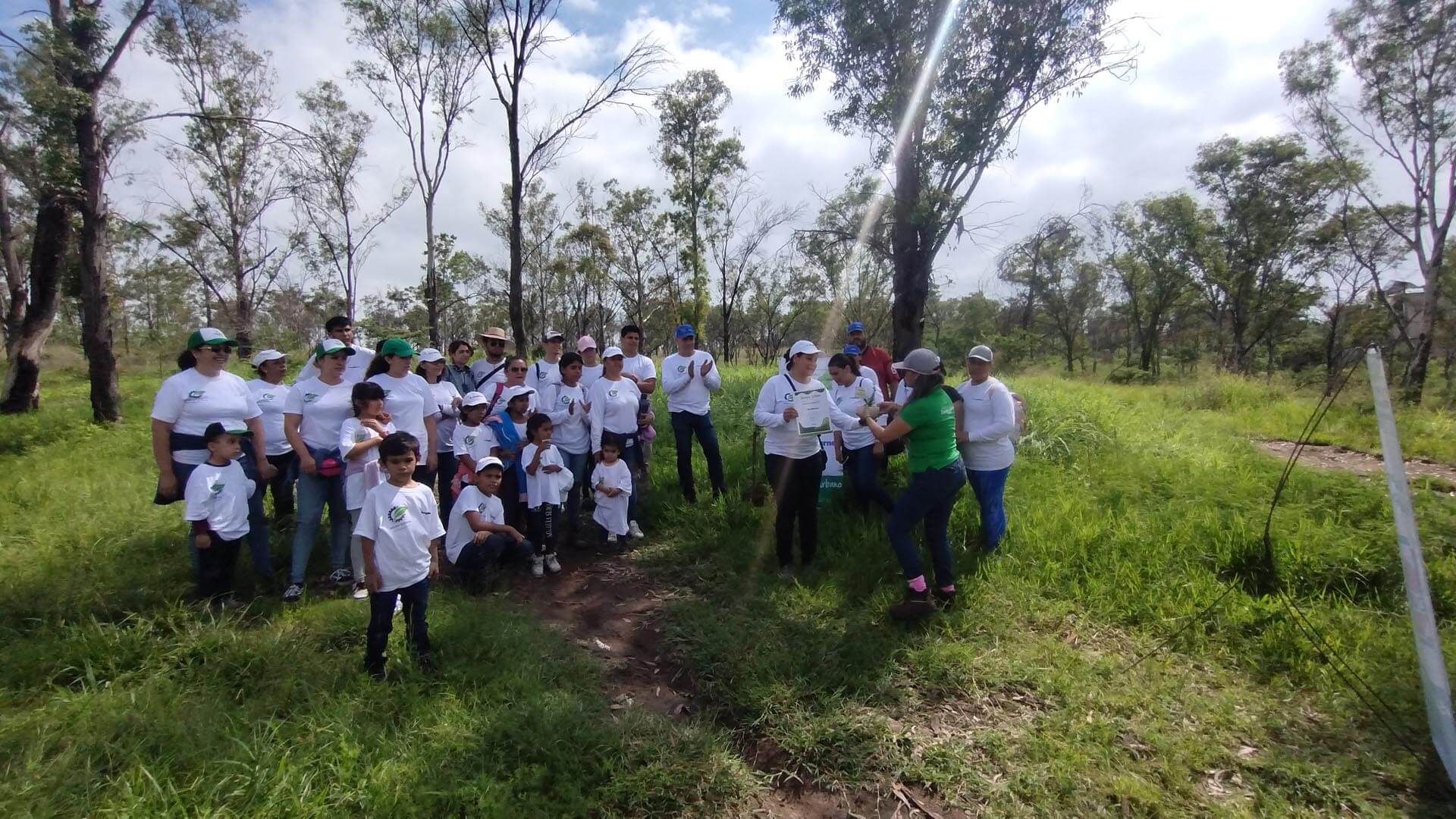 Group of adults and children in matching clothes standing in the woods