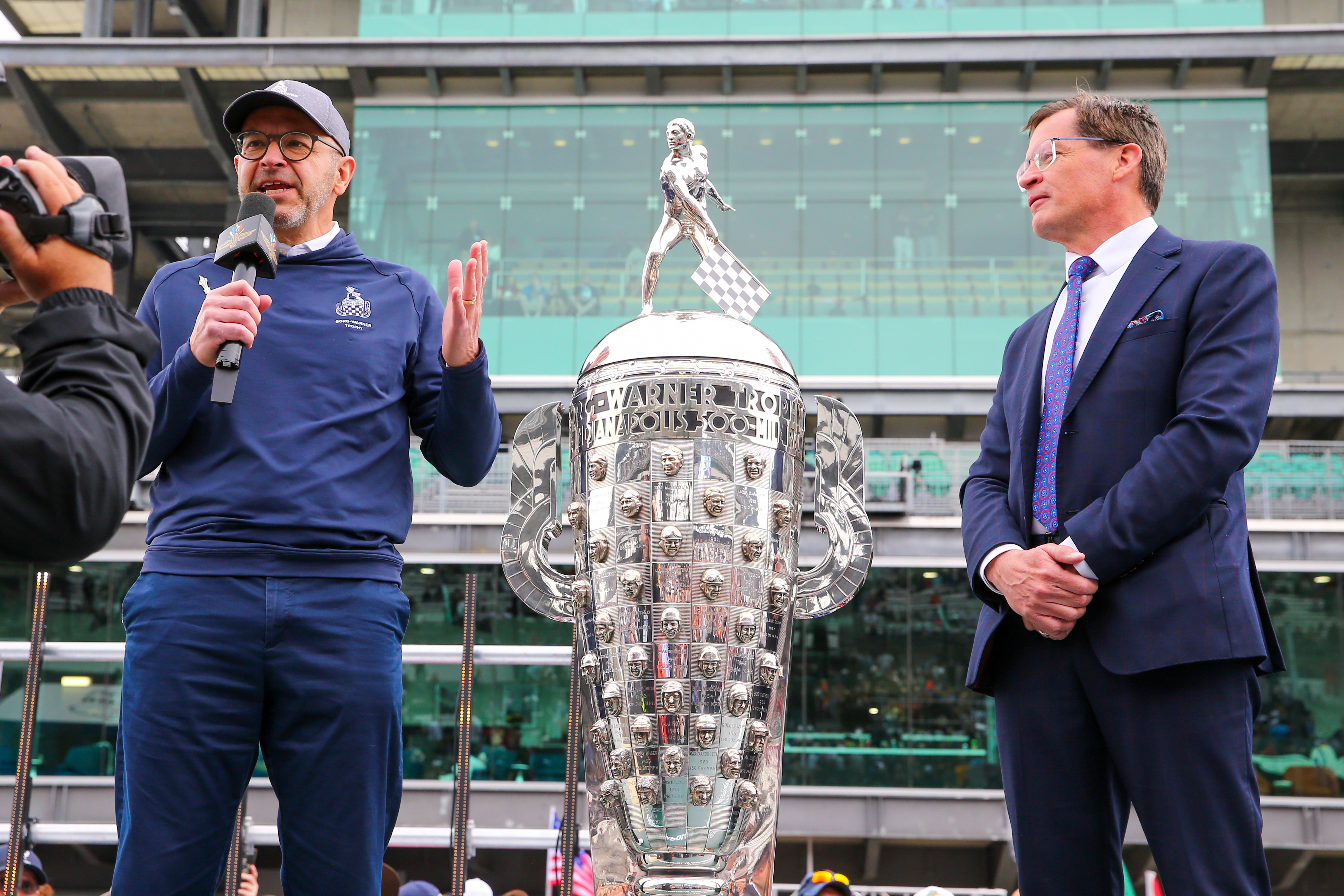 Joe Fadool talks during an interview in front of the Borg-Warner Trophy