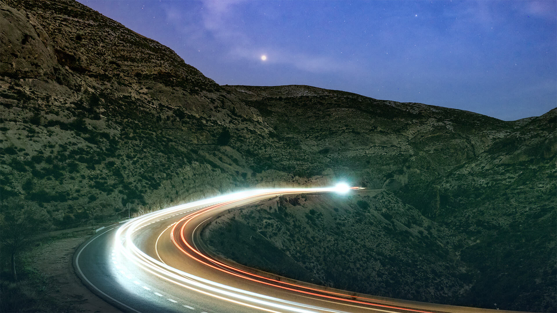 headlights at night on a mountain road