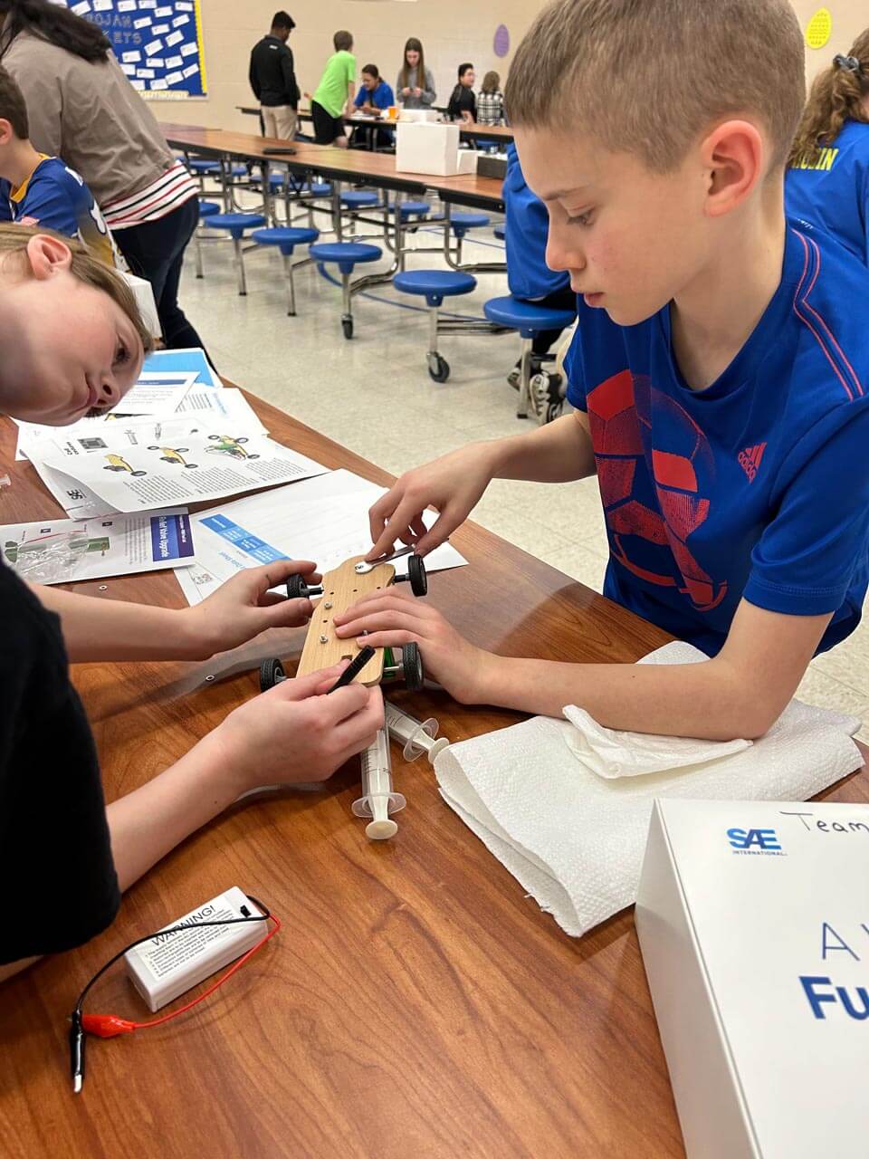 a group of kids working on a robot